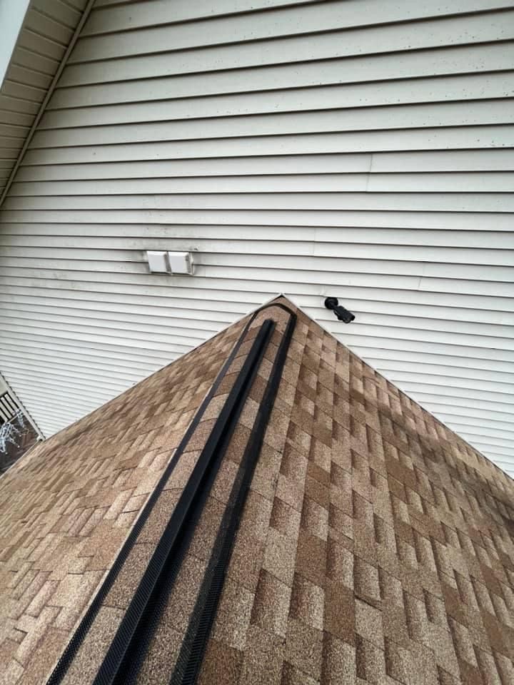 Looking up at the roof of a house with a camera on it.