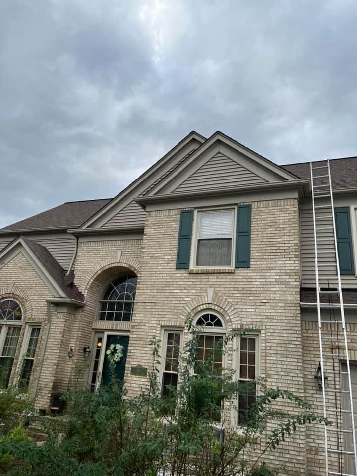 A large brick house with a ladder in front of it.