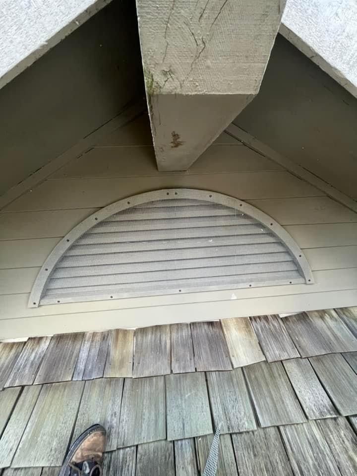 A person is standing on a wooden deck next to a wooden roof.