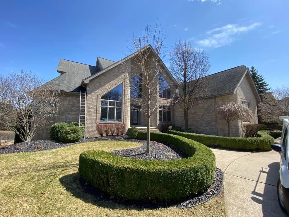 A large brick house with a car parked in front of it.
