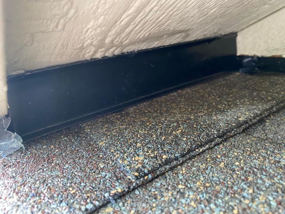 A close up of a roof with a black gutter on it.