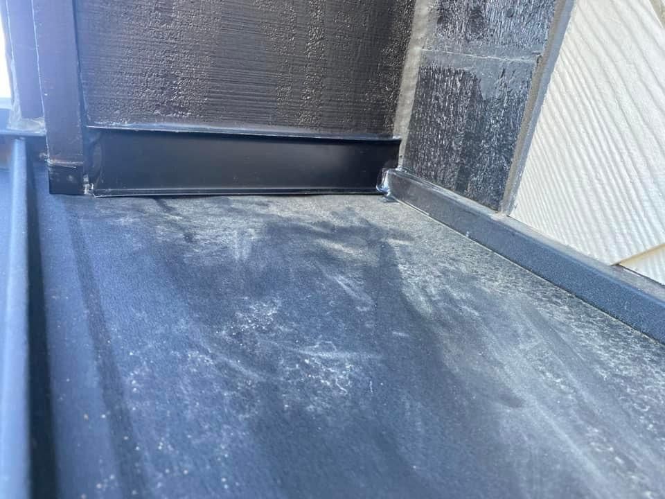 A close up of a drain on the side of a building.