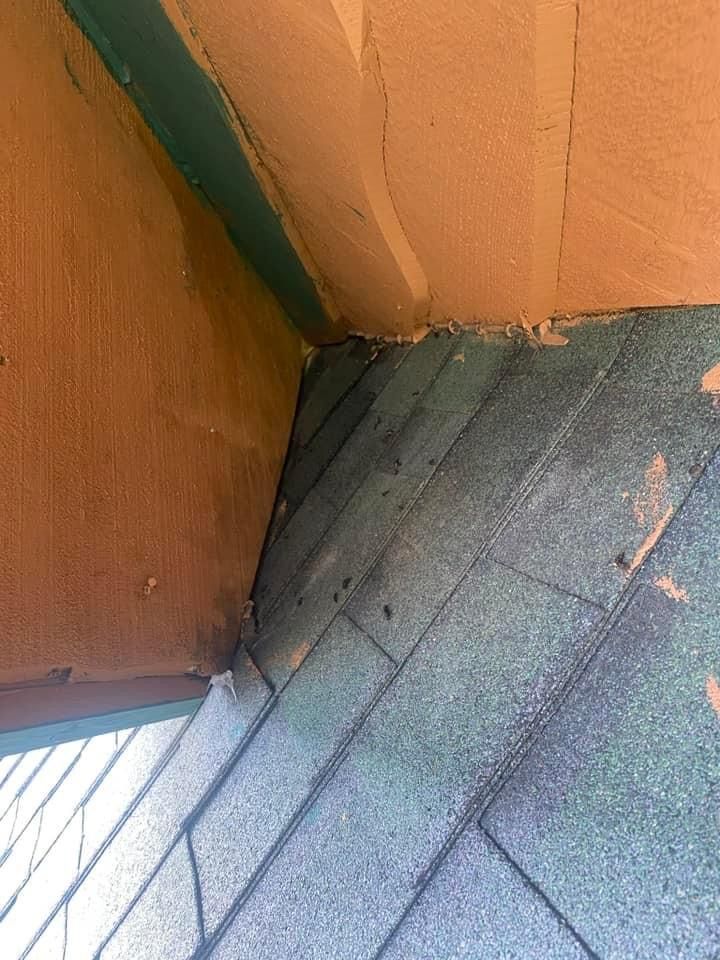 A close up of a roof with a green shingle.