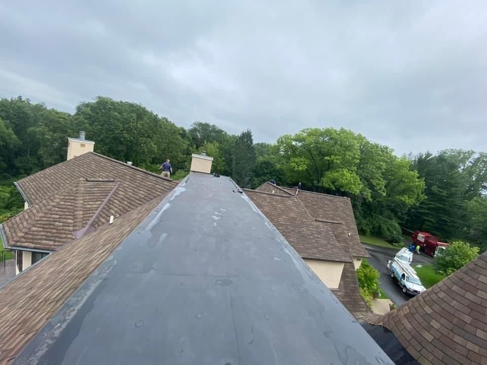 A man is standing on the roof of a house.