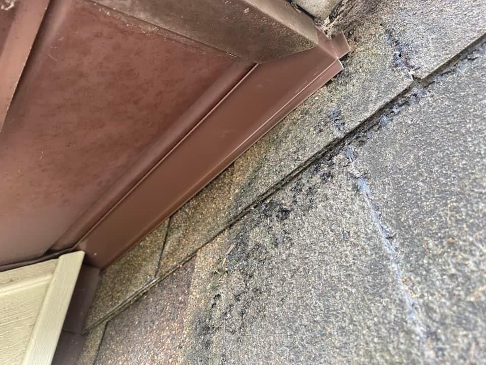 A close up of a brown gutter on a brick wall.