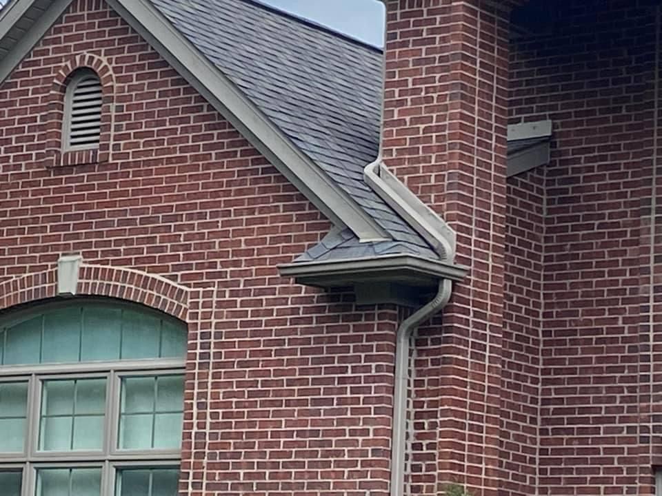 A brick building with a gutter on the side of it.