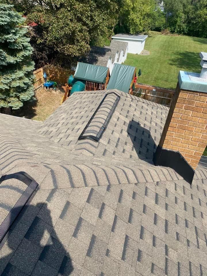 An aerial view of a roof with a chimney and a playground in the background.
