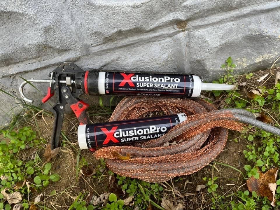 Two tubes of xclusion pro super sealant are sitting next to a rope.