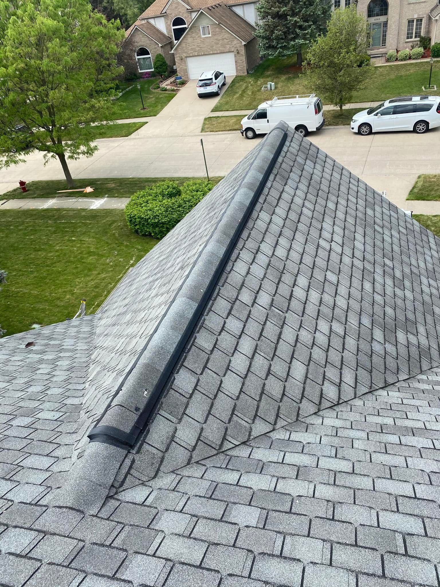 The roof of a house with a white van parked in the driveway.