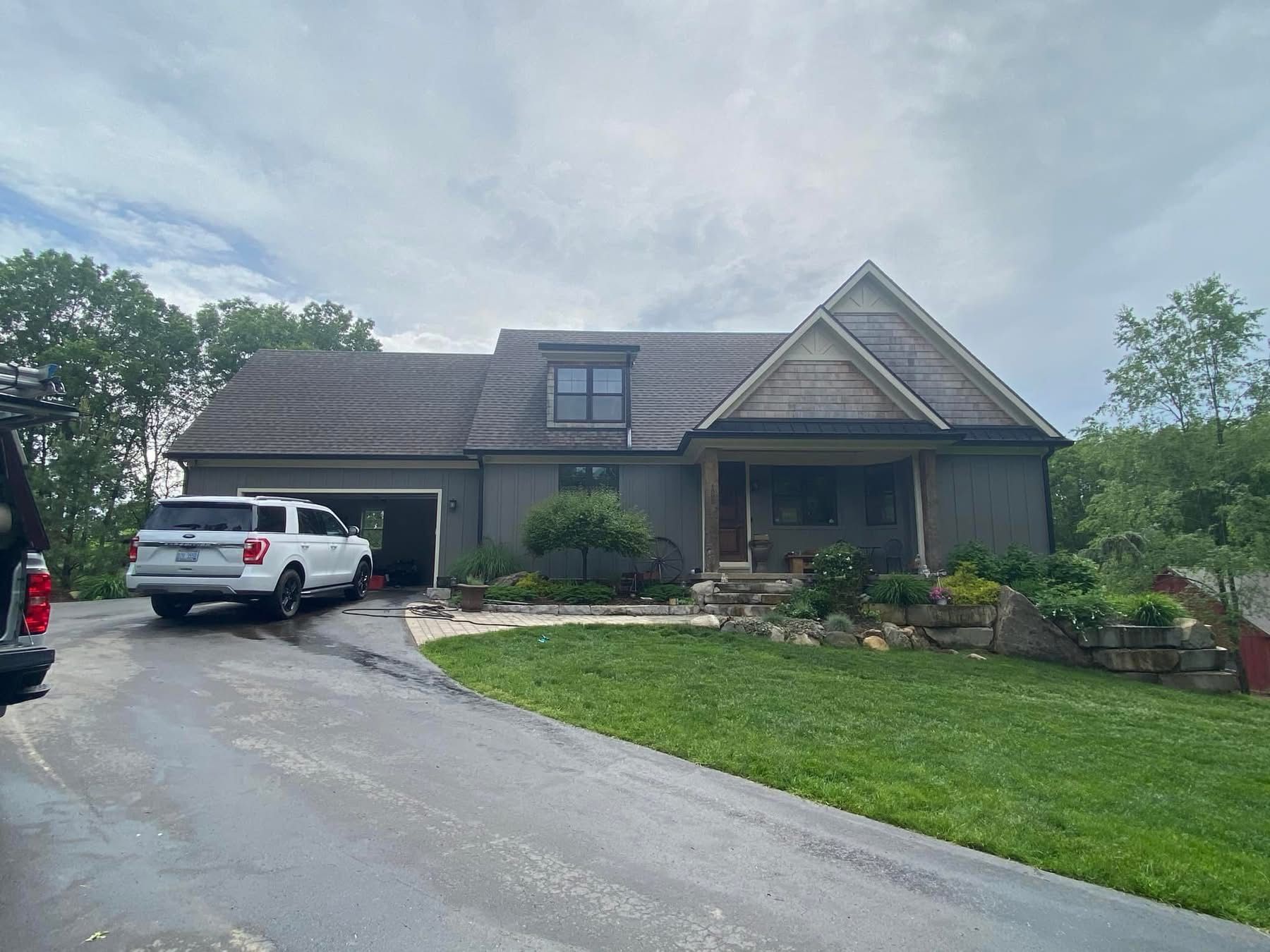 A white truck is parked in front of a large house.