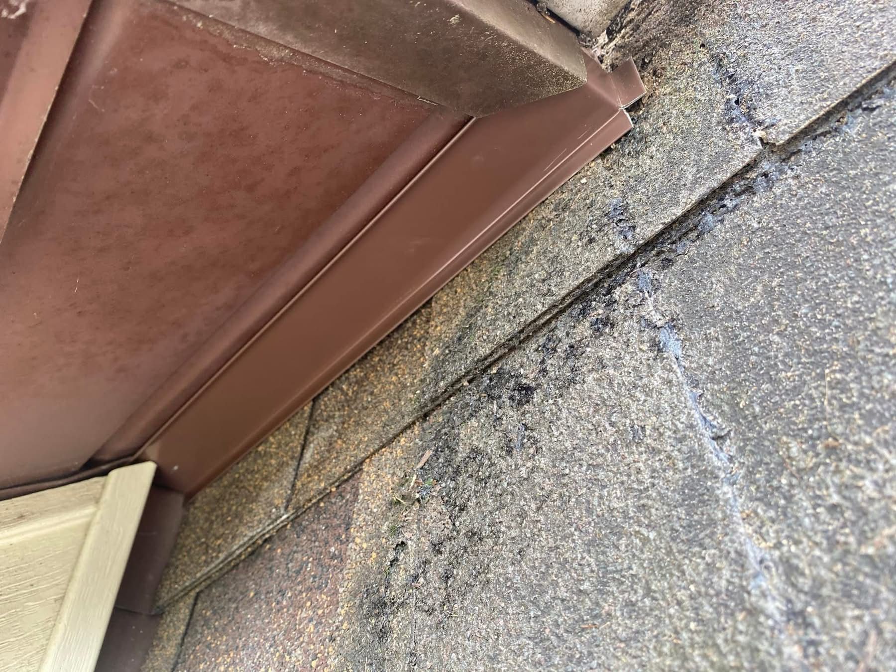 A close up of a roof with a brown gutter on it.