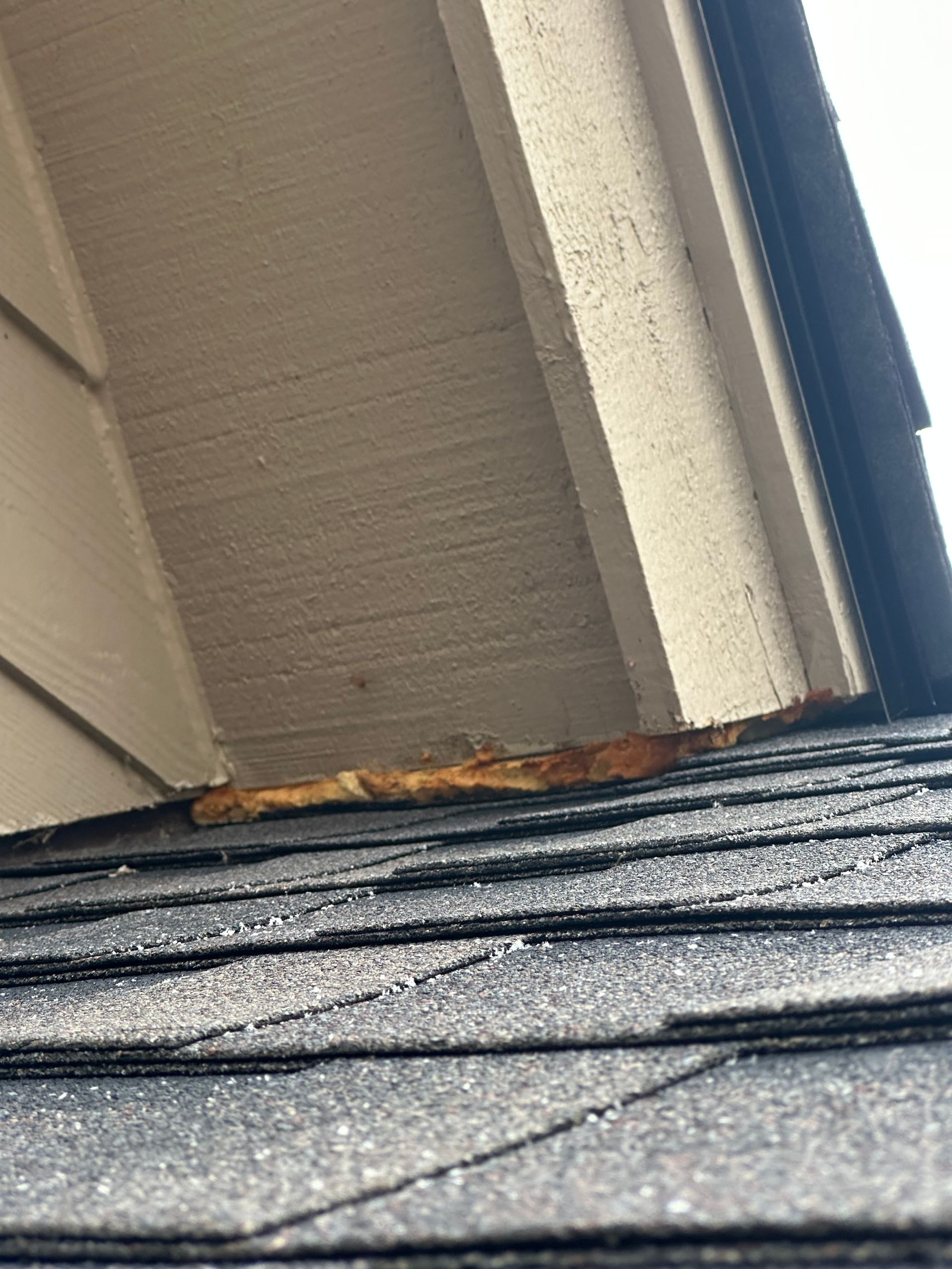 A close up of a roof with a window in the background.