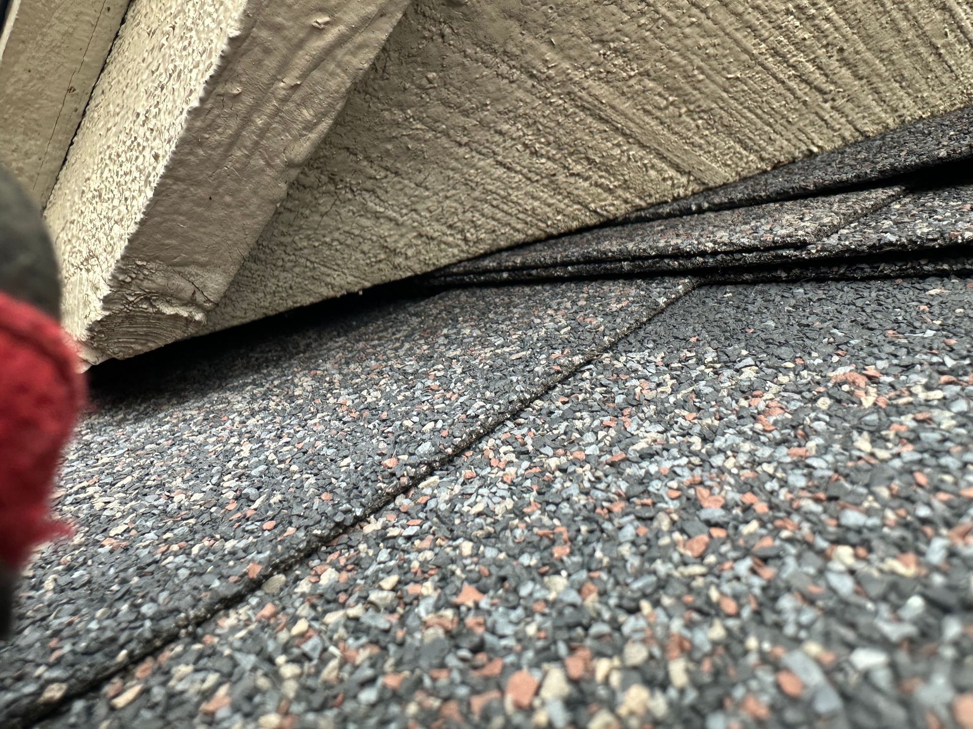 A close up of a roof with a concrete wall in the background.