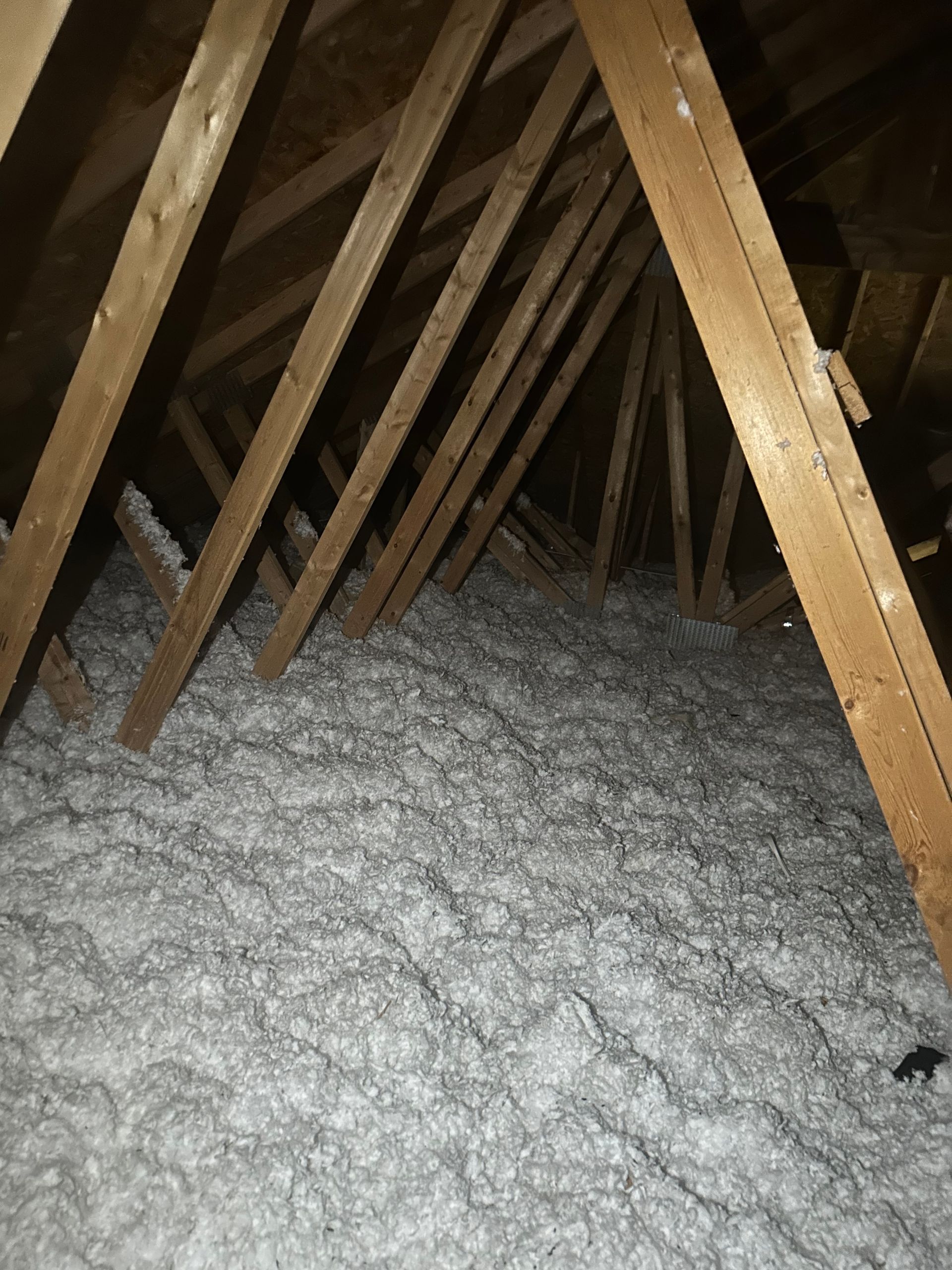 There is a lot of insulation in the attic of a house.