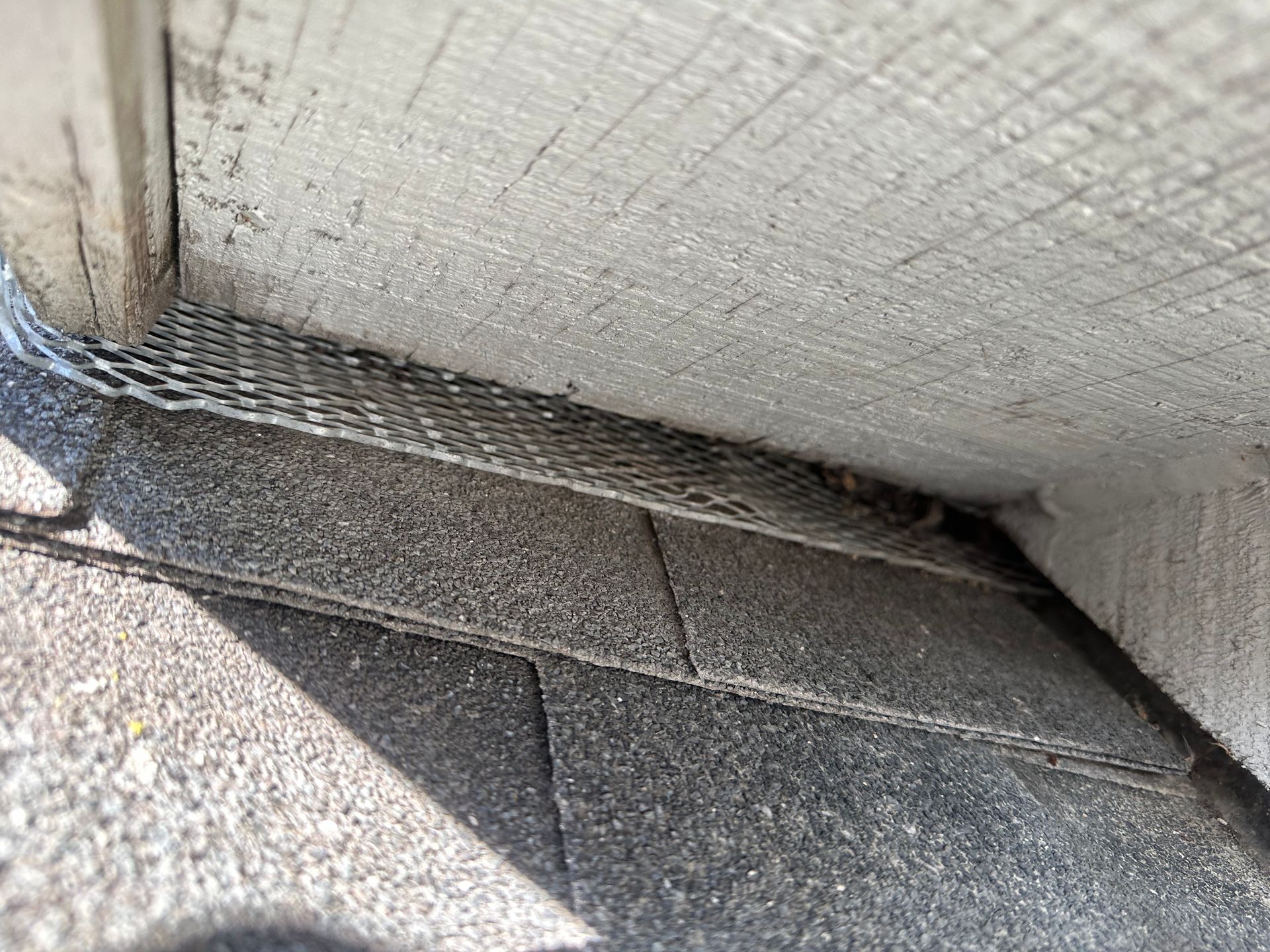 A close up of a drain on the side of a building.