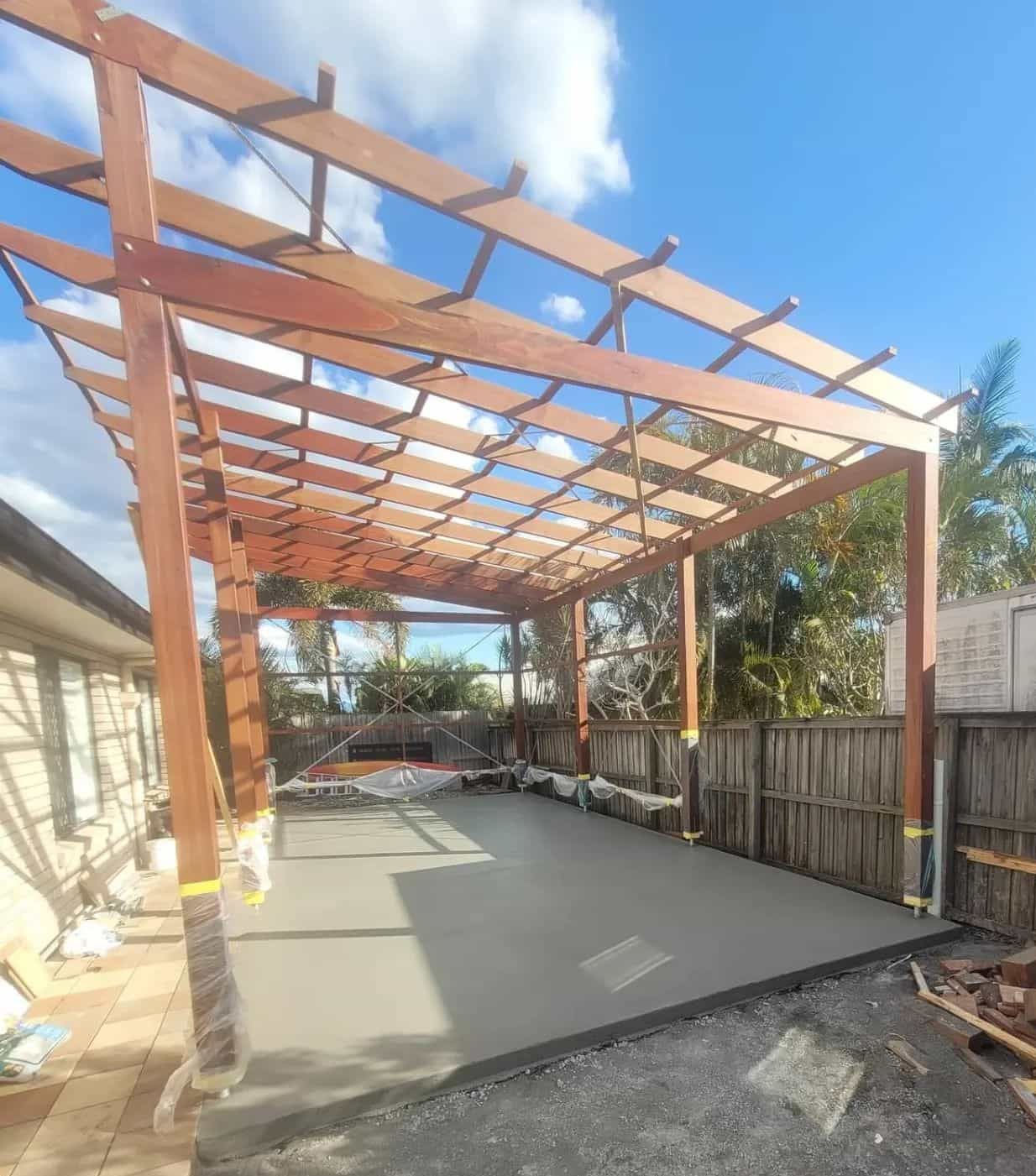 A Wooden Pergola Is Being Built Over A Concrete Driveway — C & A Concreting In Craignish, QLD