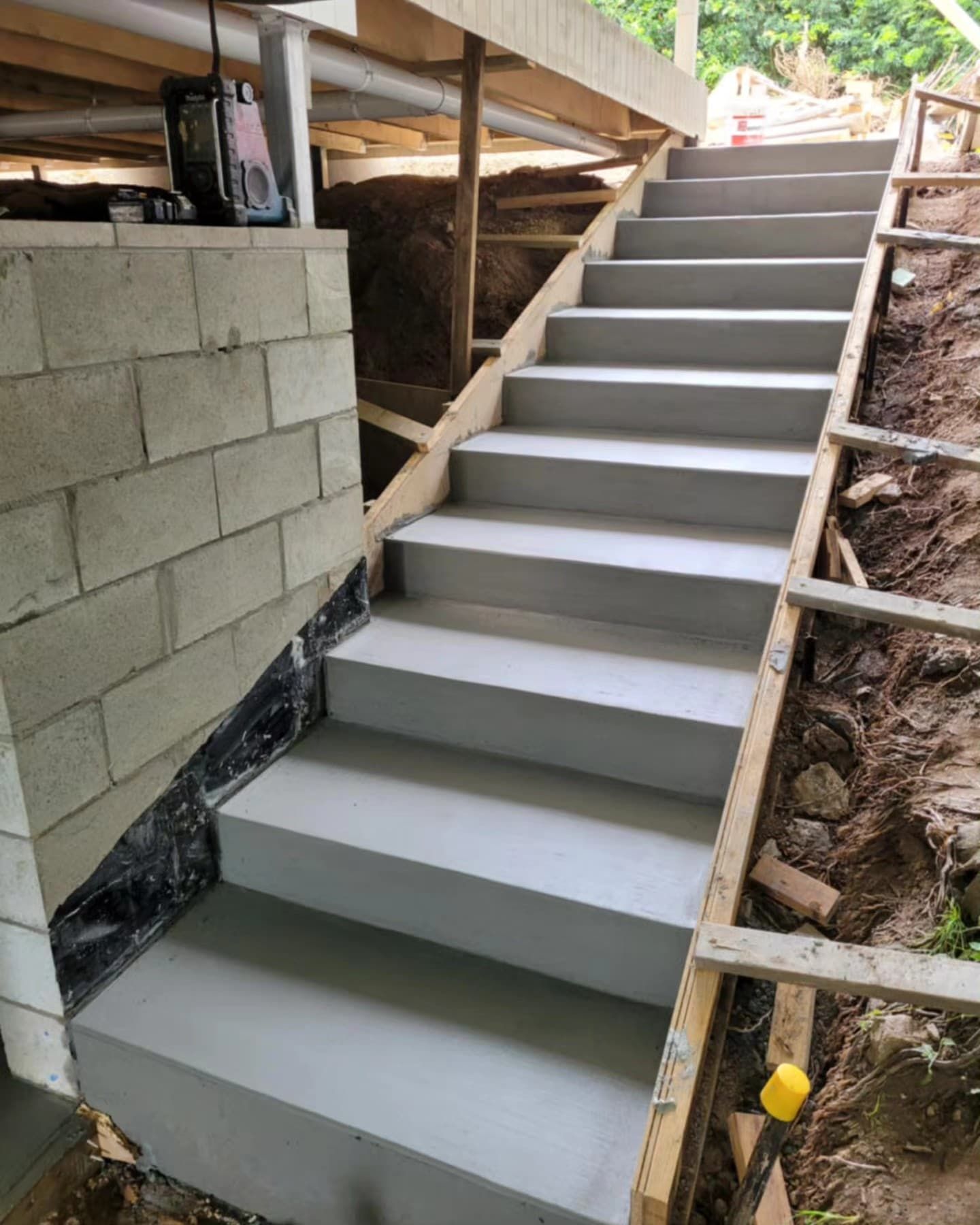 A Person Is Standing On A Concrete Sidewalk Next To A Fence — C & A Concreting In Craignish, QLD