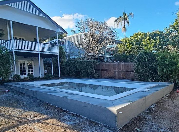 A Large Swimming Pool Is Being Built In A Backyard — C & A Concreting In Craignish, QLD