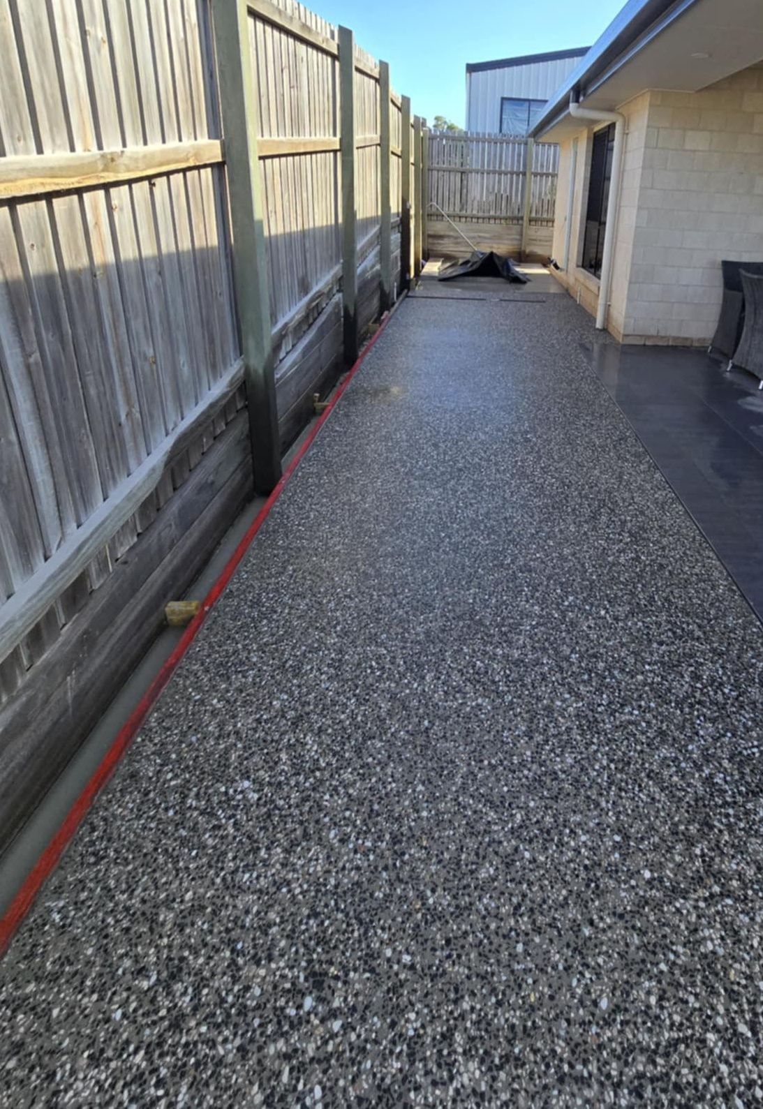 A Concrete Walkway Leading To A House With Trees In The Background — C & A Concreting In Craignish, QLD