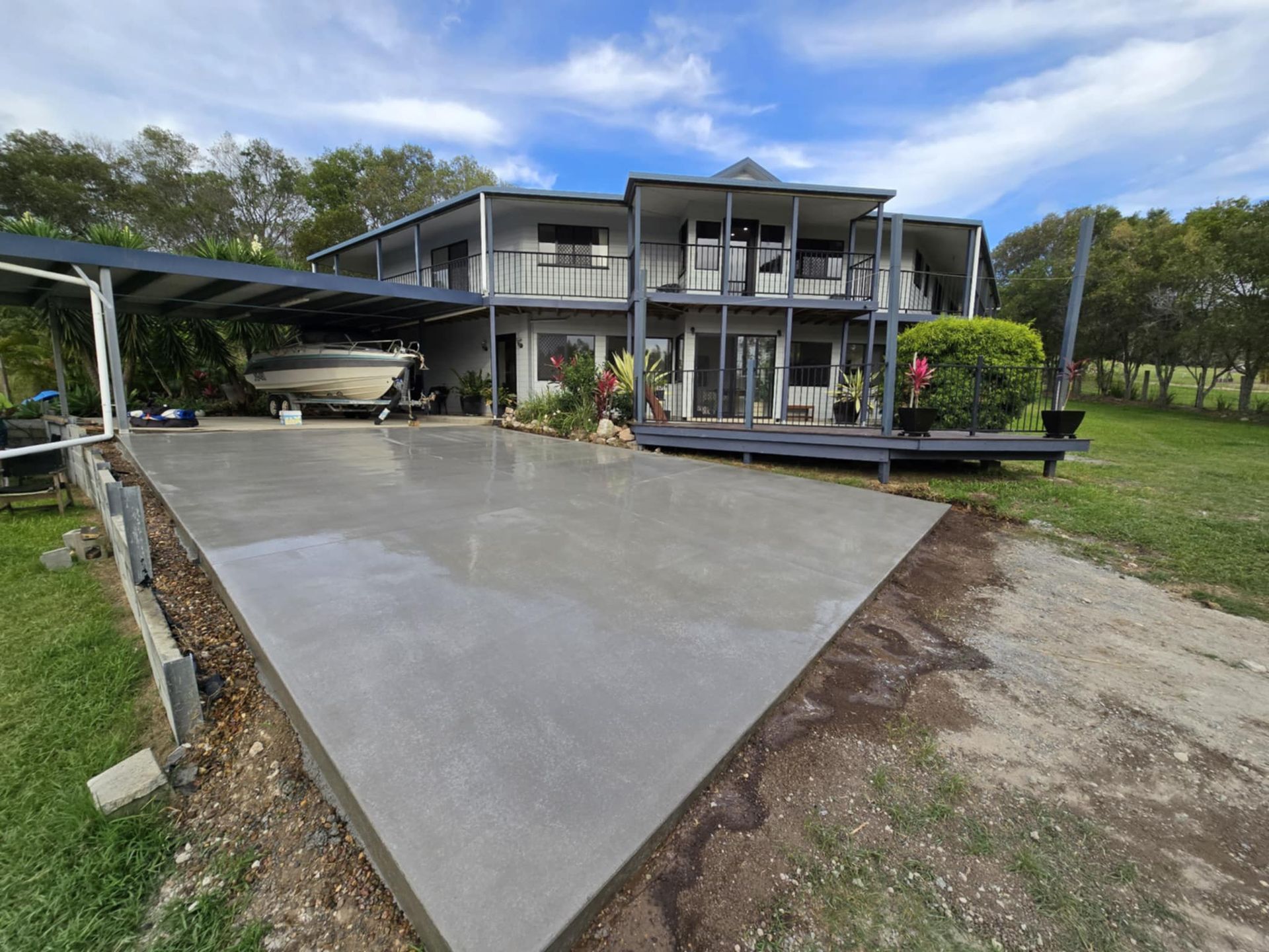 A Driveway Leading To A Large House On A Sunny Day — C & A Concreting In Craignish, QLD