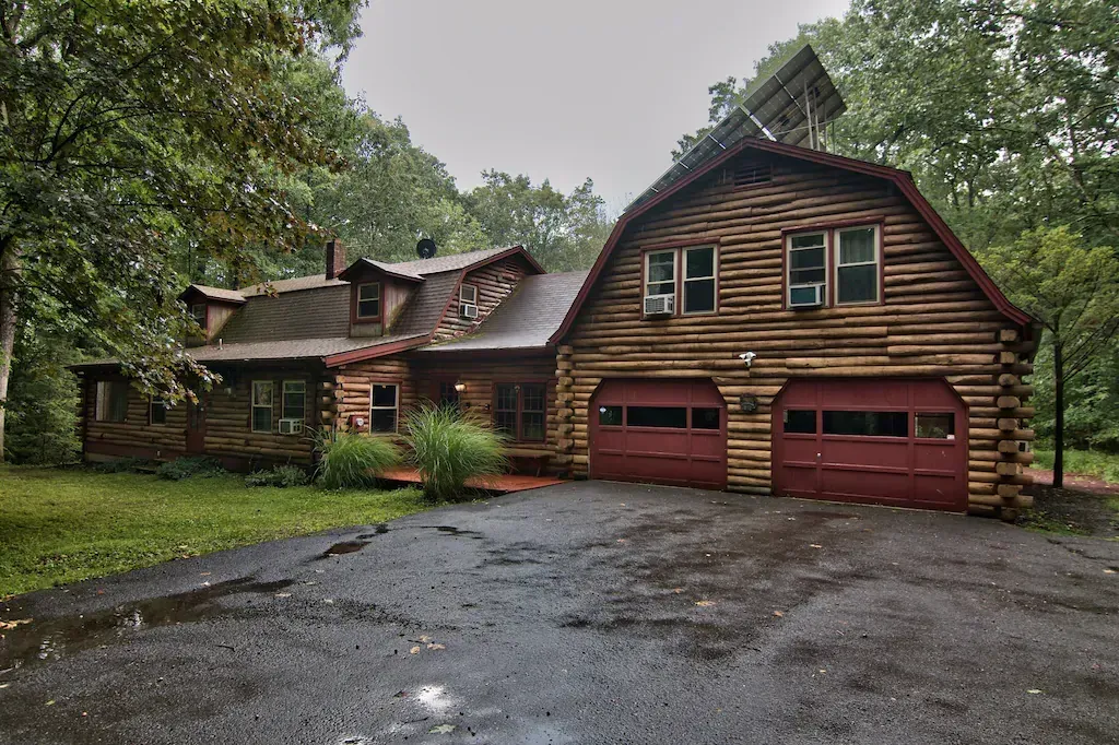 A large log cabin with two red garage doors