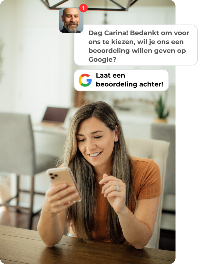 Een vrouw zit aan een tafel en kijkt naar haar telefoon