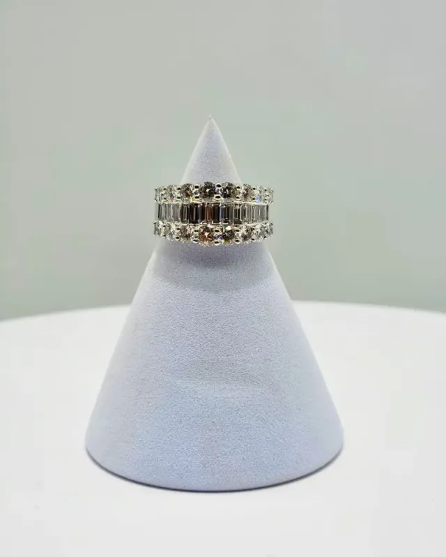 Diamond rings stacked on a white cone display against a light background