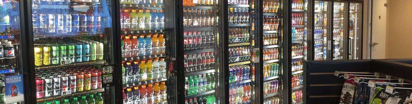 A row of refrigerators filled with lots of drinks in a store.