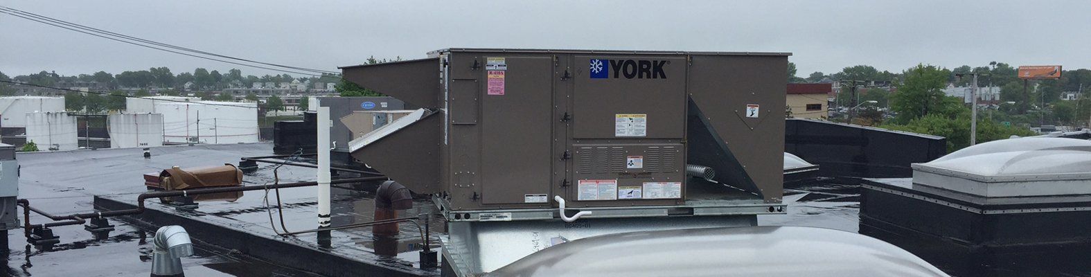 A large air conditioner is sitting on top of a roof.