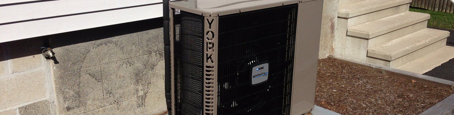 A telephone booth is sitting on the side of a building next to stairs.