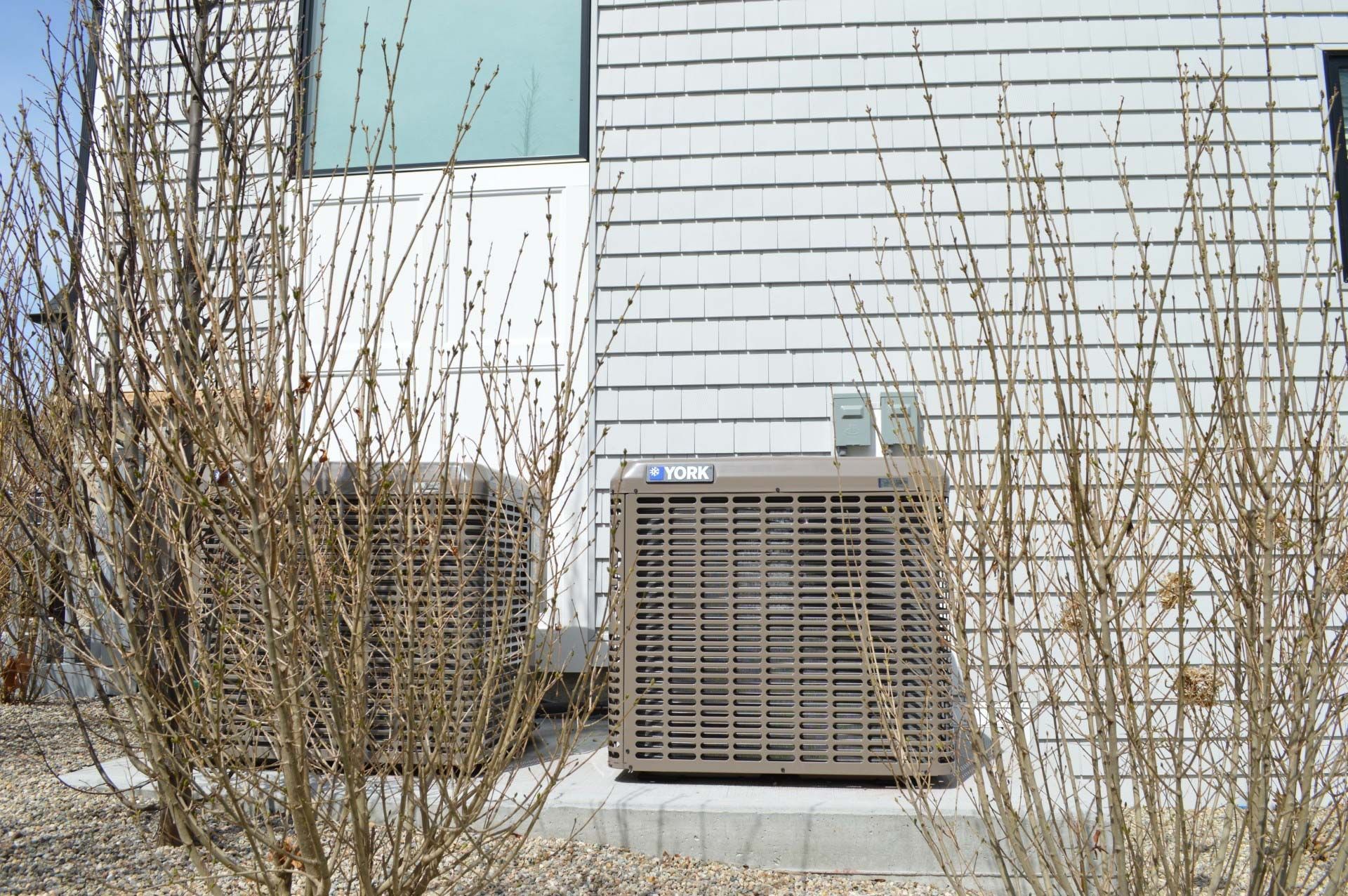 An air conditioner is sitting outside of a brick building