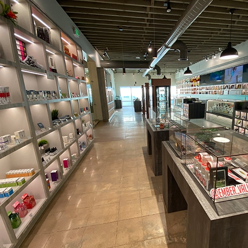 Interior view of a well-lit cannabis dispensary with product displays on shelves and countertops.