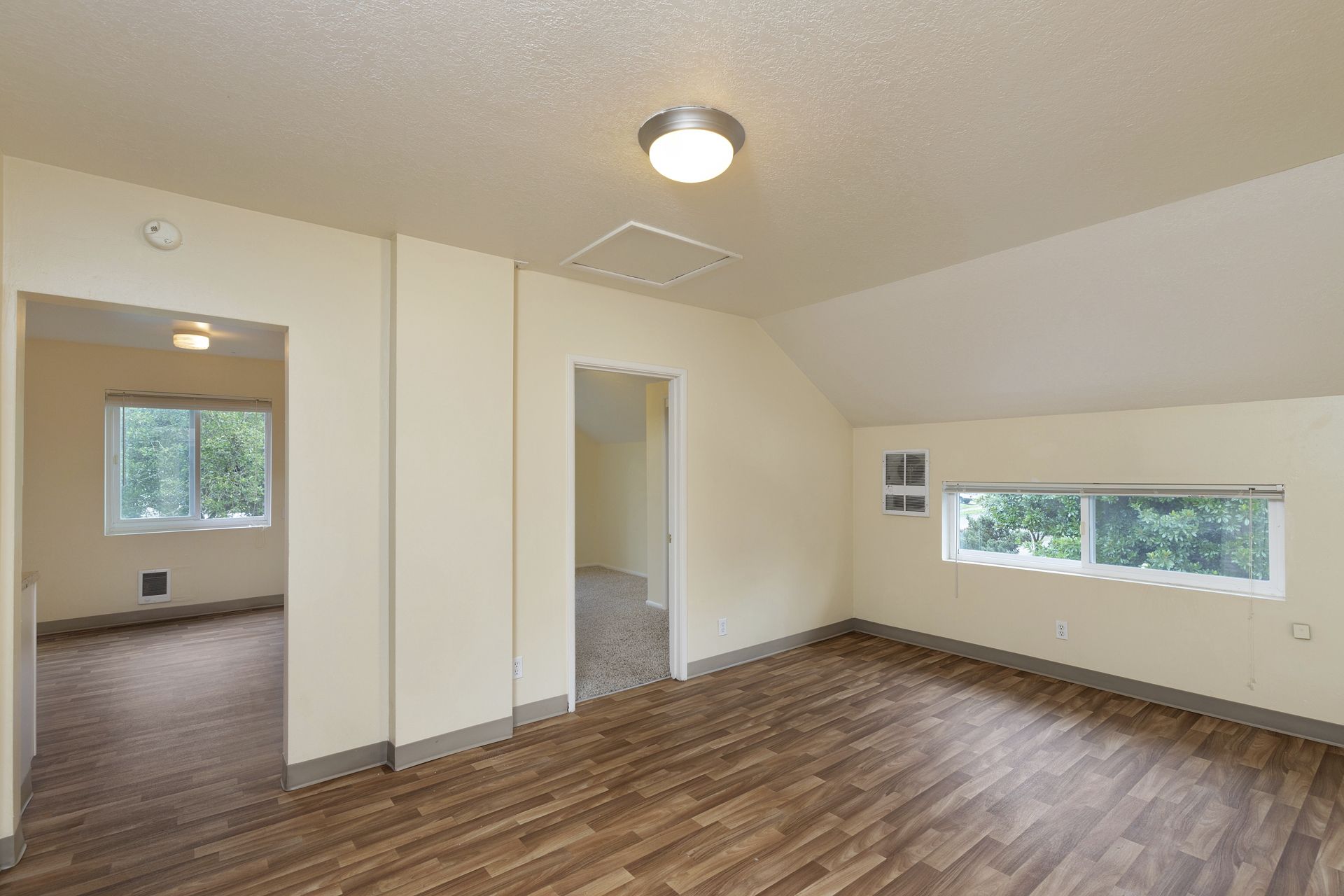 An empty room with hardwood floors and white walls.