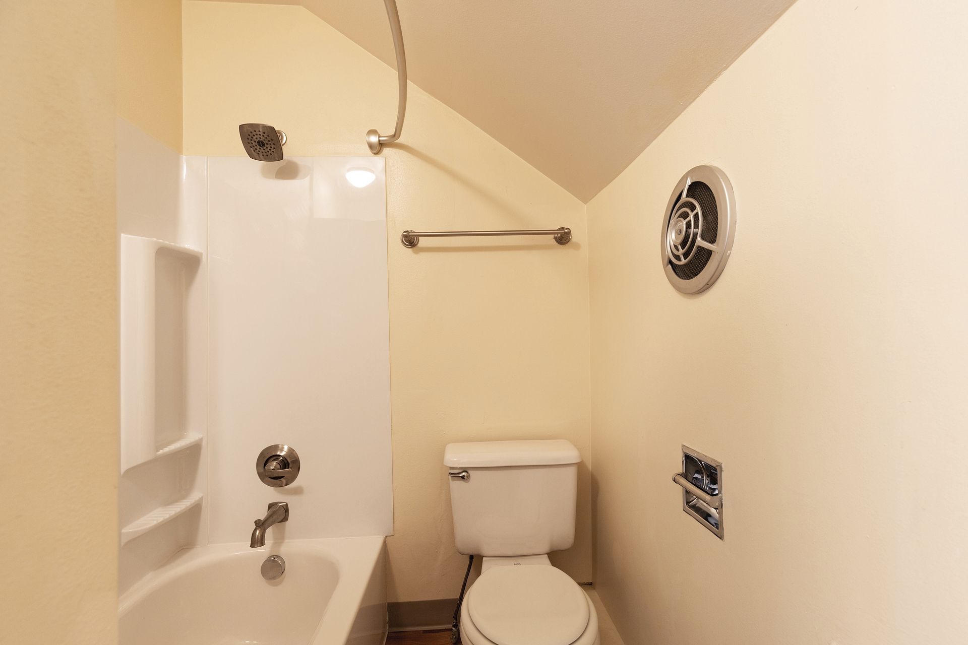 A bathroom with a toilet , bathtub and shower.