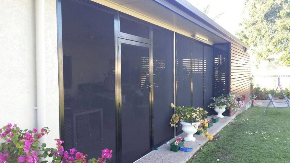 A House with A Screened in Porch and Flowers in Front of It — North Queensland Glass & Glazing In Cannonvale, QLD