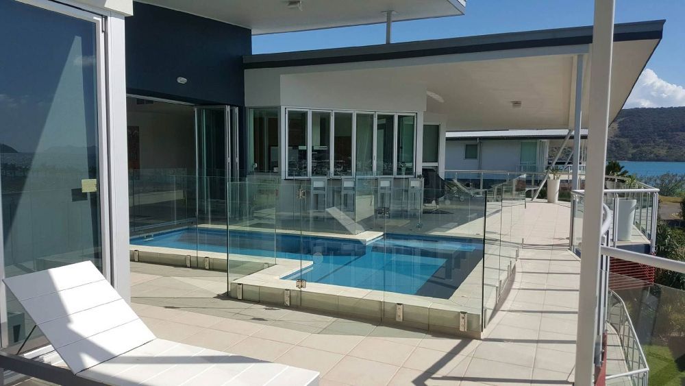 A Large House with A Swimming Pool in Front of It — North Queensland Glass & Glazing In Cannonvale, QLD