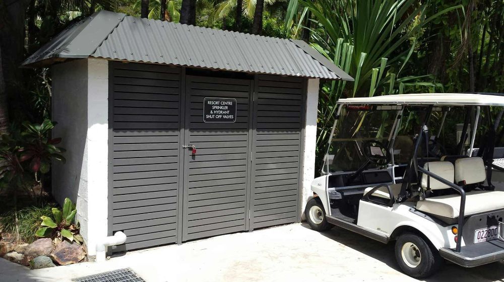 A Golf Cart Is Parked in Front of A Shed — North Queensland Glass & Glazing In Cannonvale, QLD