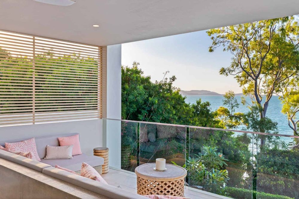 A Balcony with A View of The Ocean and Trees — North Queensland Glass & Glazing In Cannonvale, QLD