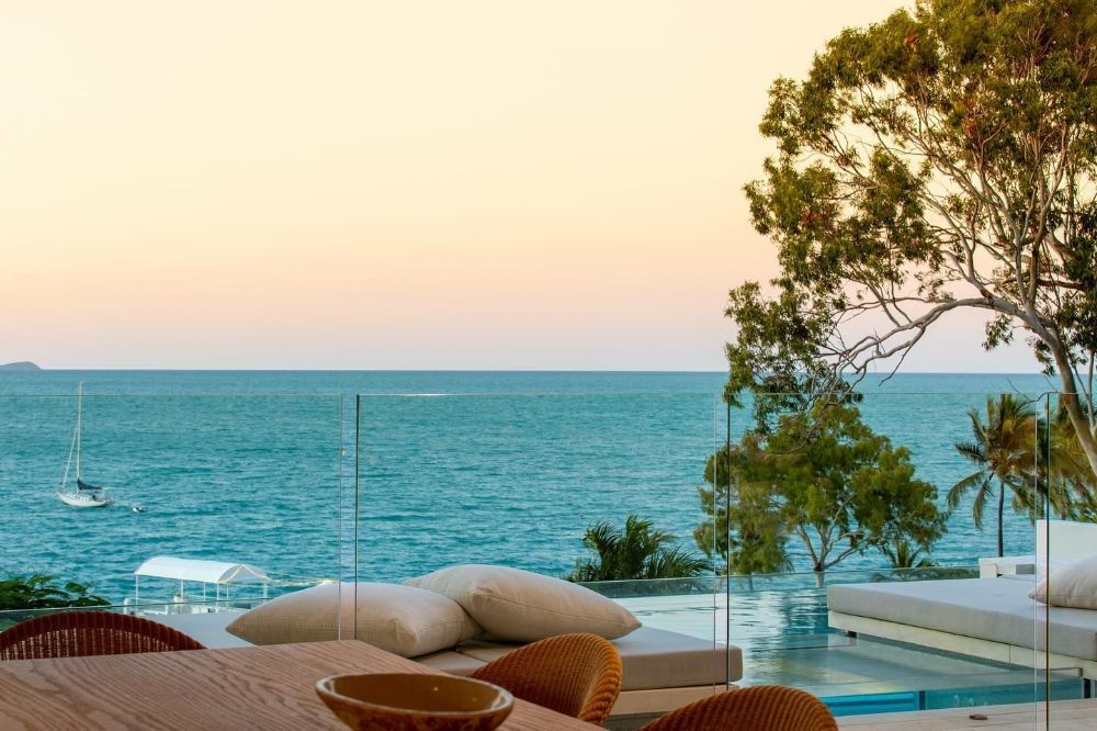 A View of The Ocean from A Balcony with A Table and Chairs — North Queensland Glass & Glazing In Proserpine, QLD