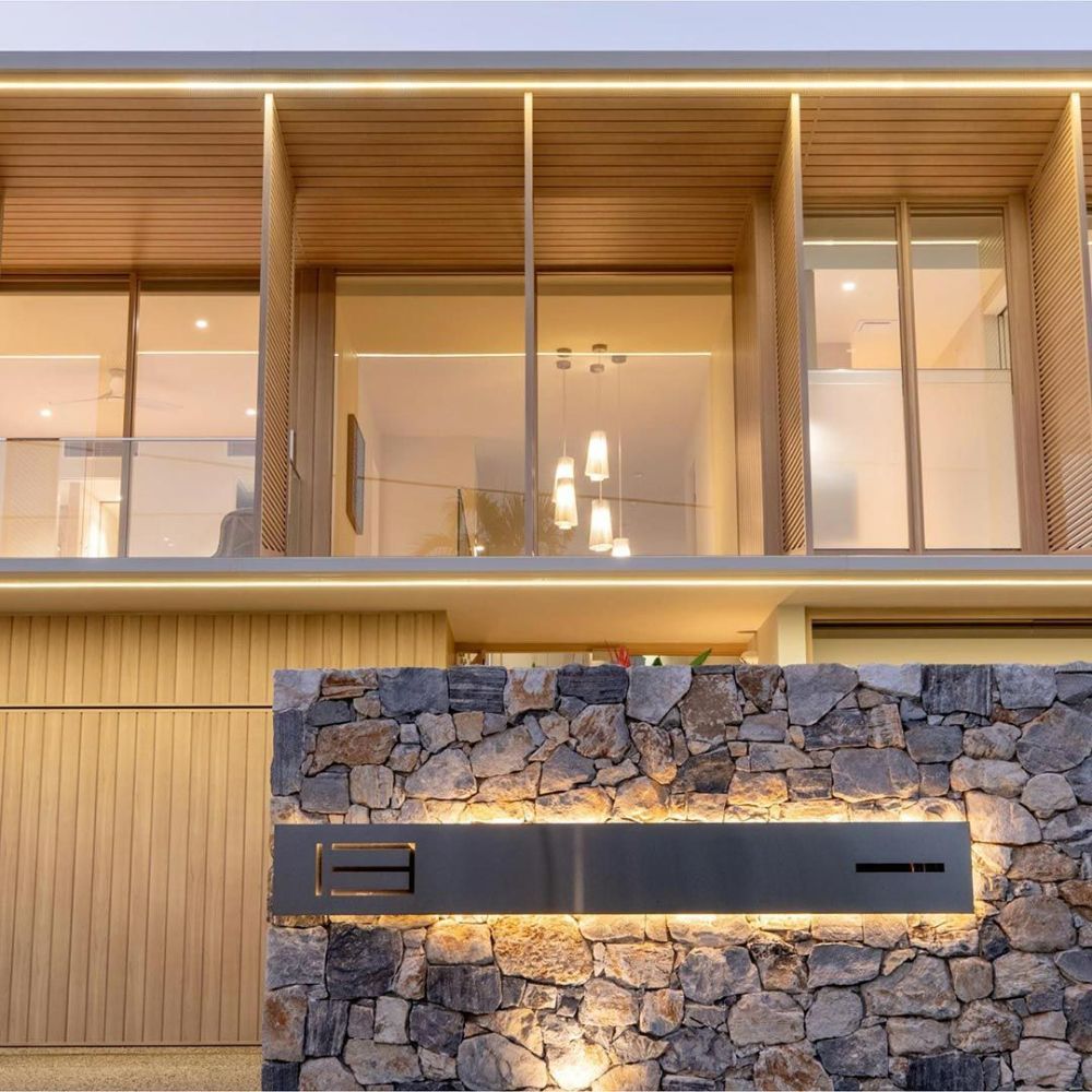 The Front of A House with A Stone Wall and A Lot of Windows — North Queensland Glass & Glazing In Cannonvale, QLD