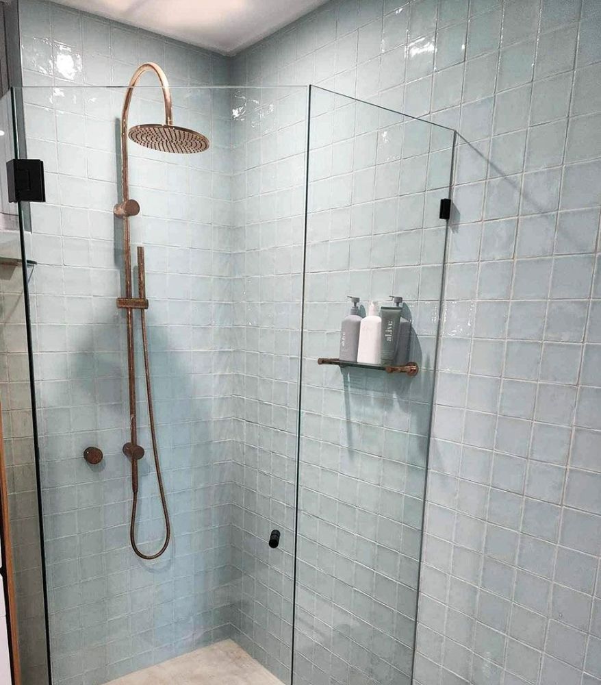 A Bathroom with Blue Tiles and A Walk in Shower with A Glass Door — North Queensland Glass & Glazing In Cannonvale, QLD