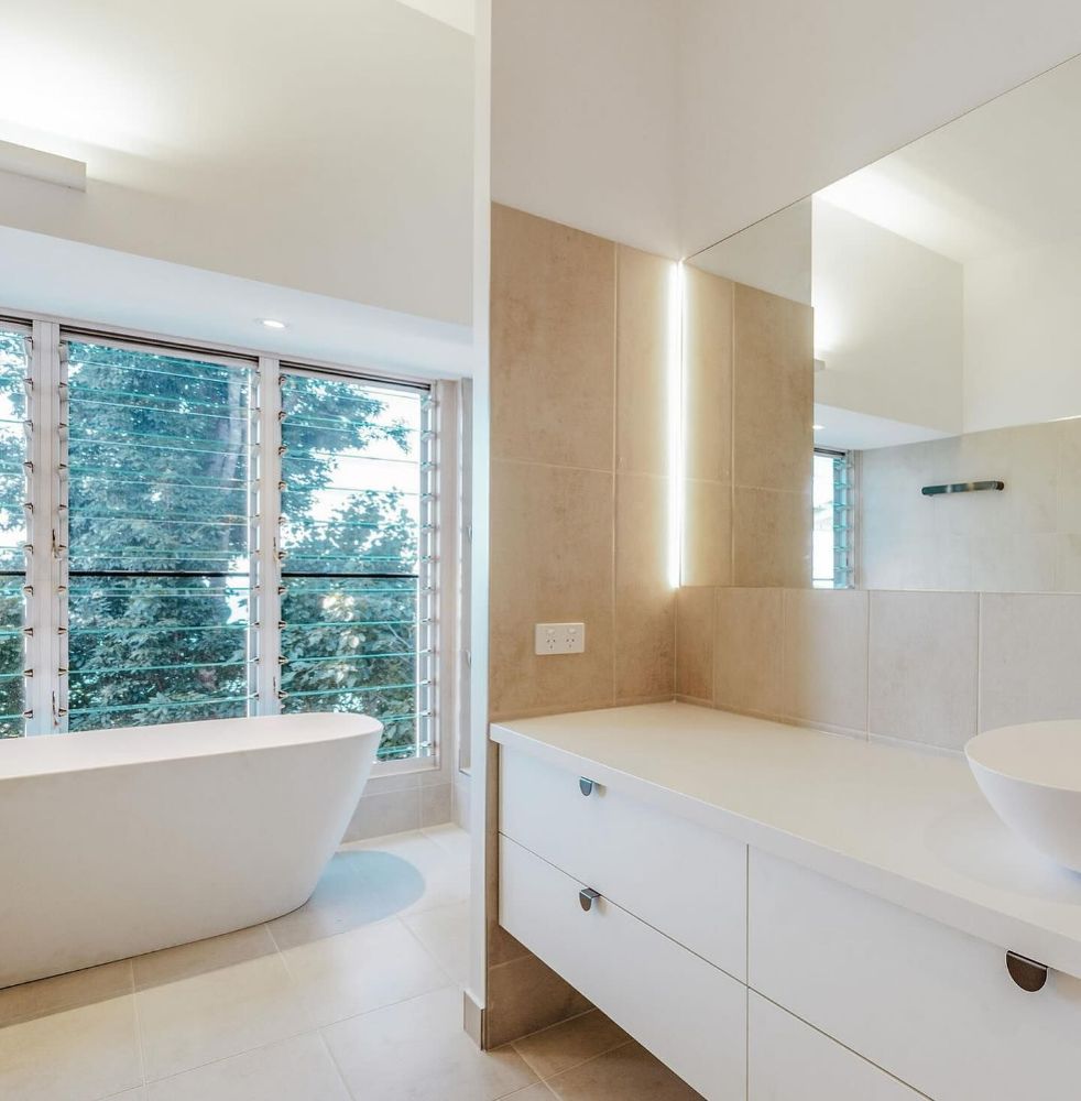 A Bathroom with A Tub and Sink and A Large Window — North Queensland Glass & Glazing In Cannonvale, QLD