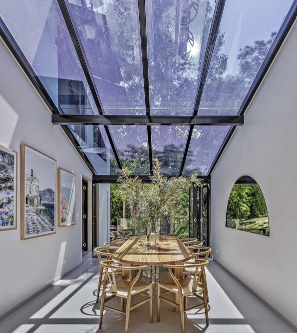 A Dining Room with A Glass Ceiling and A Table and Chairs — North Queensland Glass & Glazing In Cannonvale, QLD