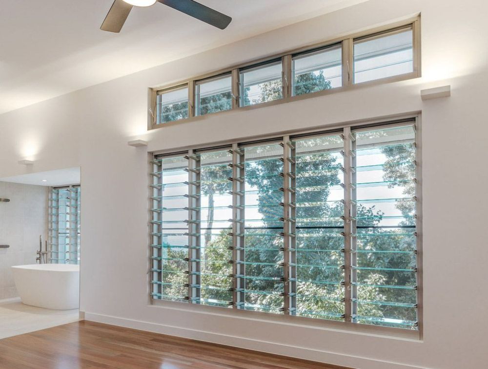 An Empty Room with A Lot of Windows and A Ceiling Fan — North Queensland Glass & Glazing In Cannonvale, QLD