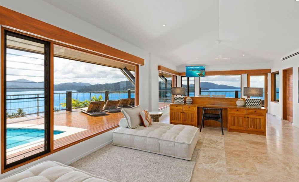 A Living Room with A Couch, Desk, and Large Windows — North Queensland Glass & Glazing In Cannonvale, QLD
