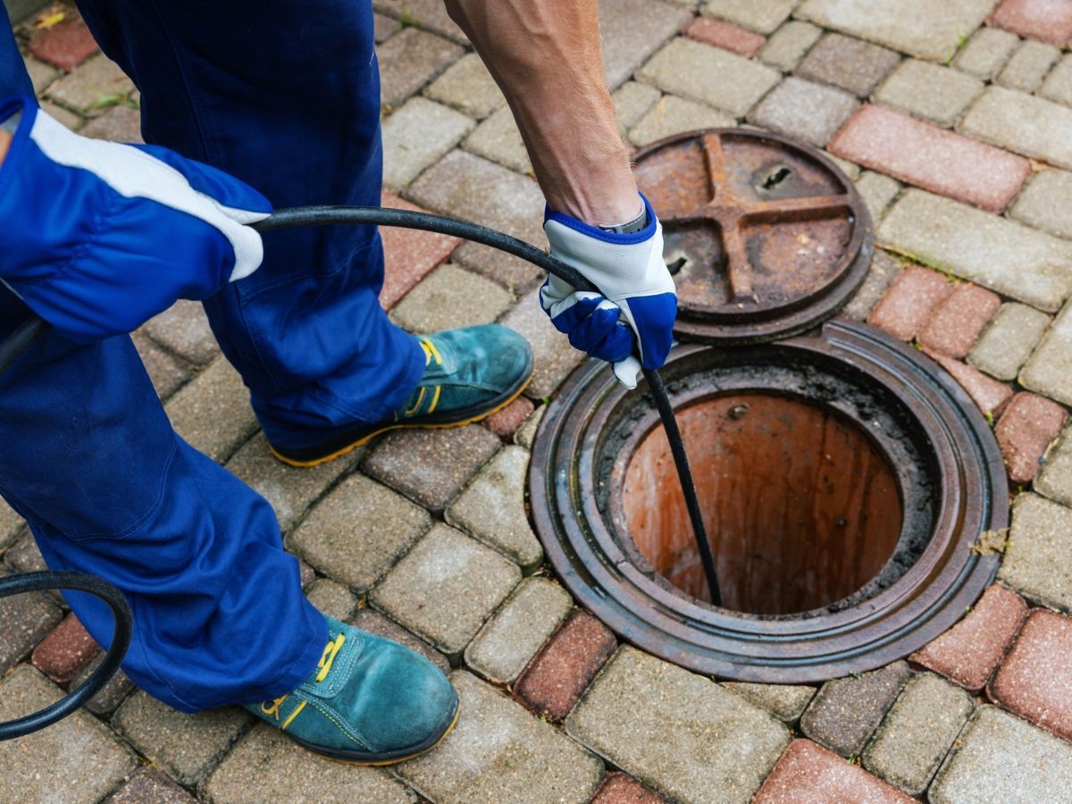A man is fixing a pipe with a wrench