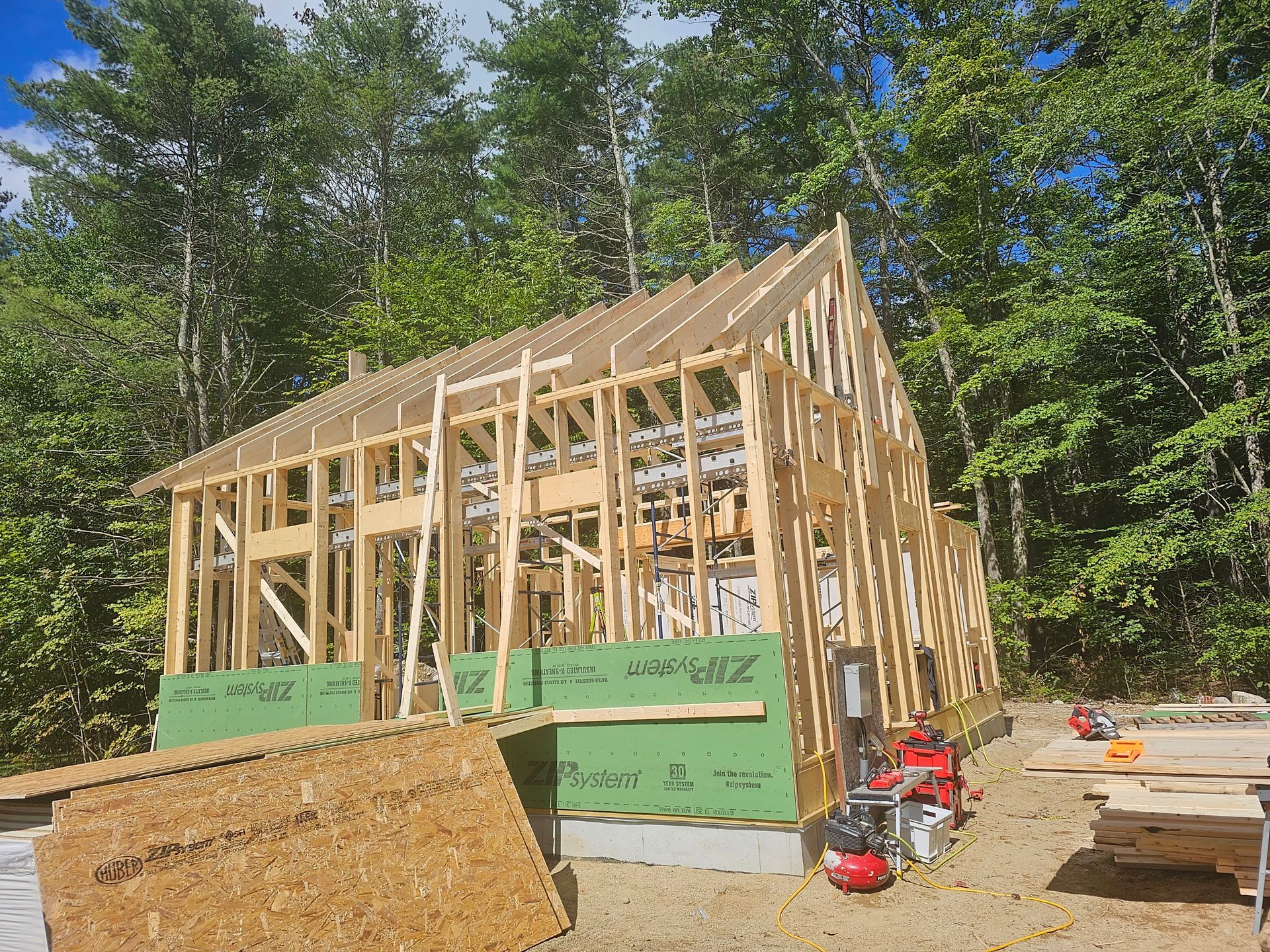 a house is being built in the woods and the walls are covered in zip system