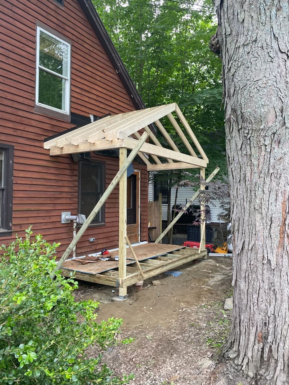 A wooden porch is being built on the side of a house.