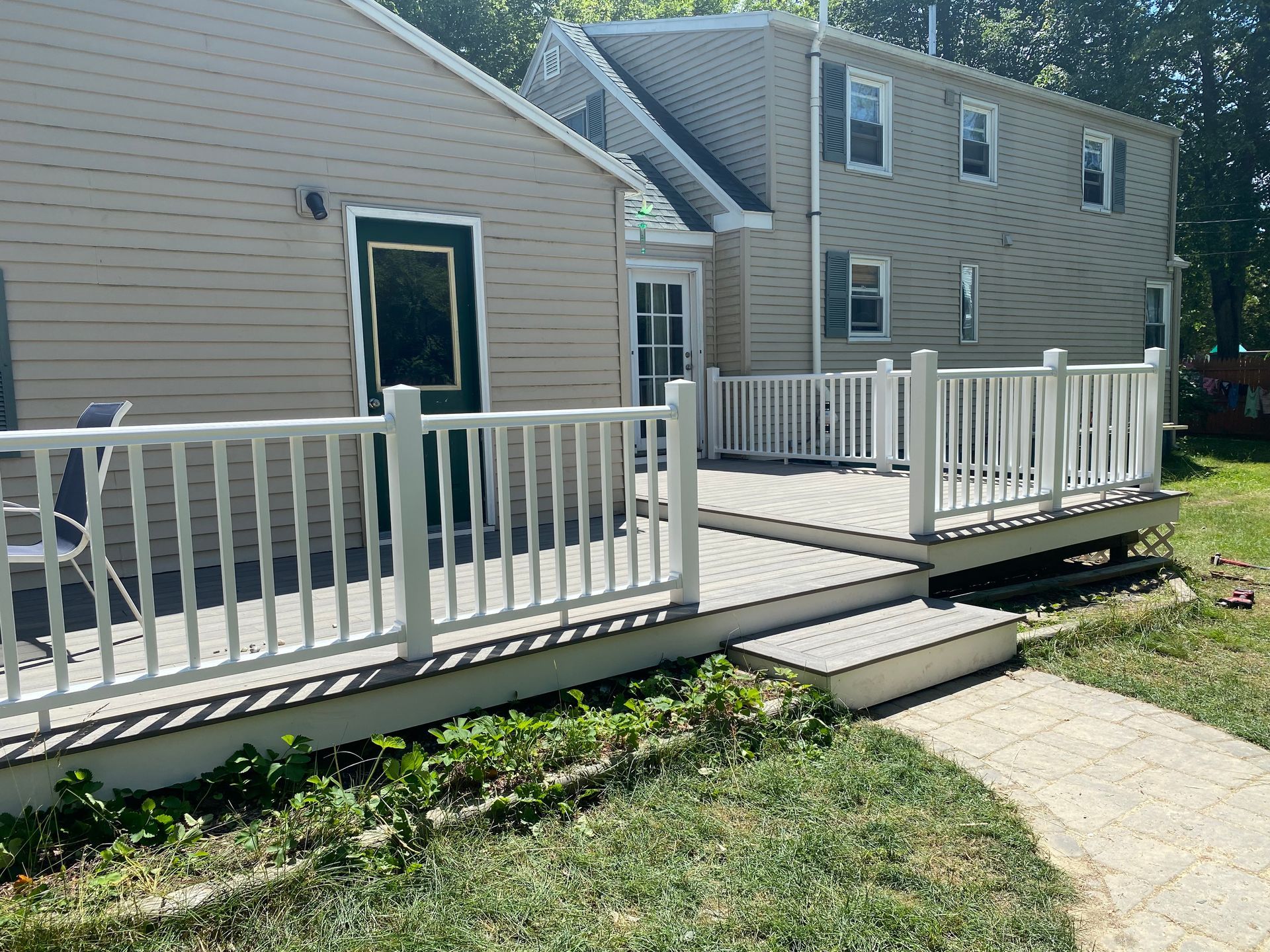 A house with a large deck in front of it