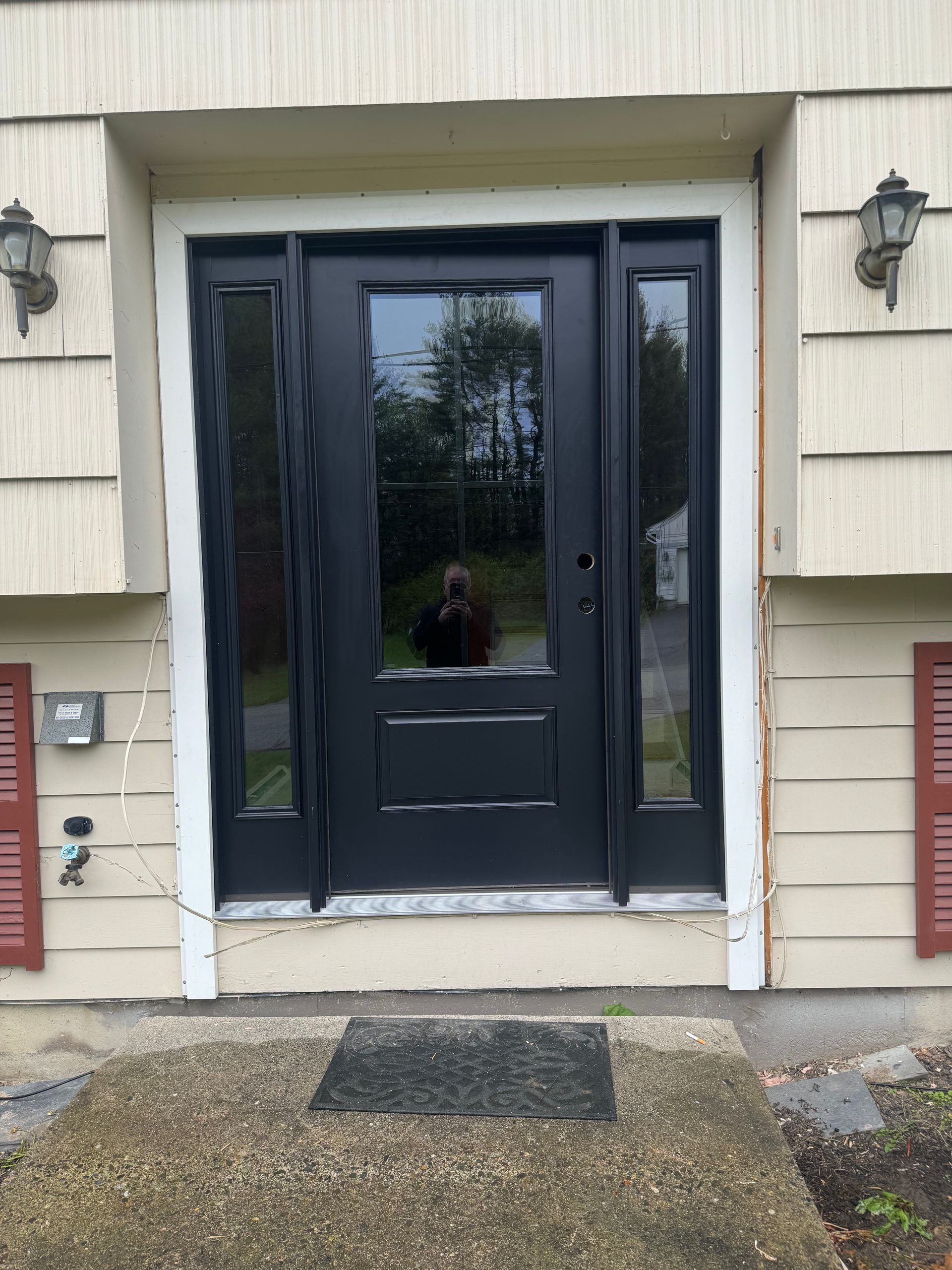 A black door with a reflection of a person in it